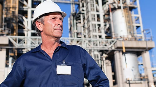 male engineer gazing infront of petrochemical plant